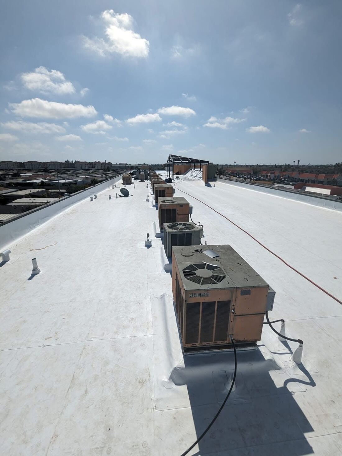 Newly installed white TPO flat roofing membrane on a commercial building